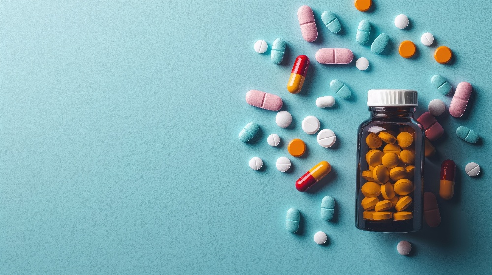 Top view of medicine bottle with scattered pills on colorful background